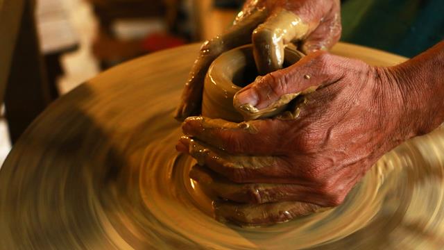 hands on a pottery piece being made
