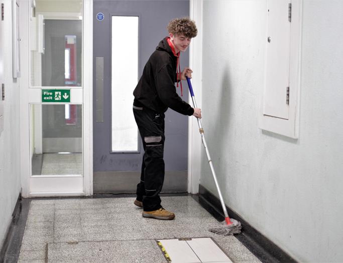 Lewis Caretaker mopping floor