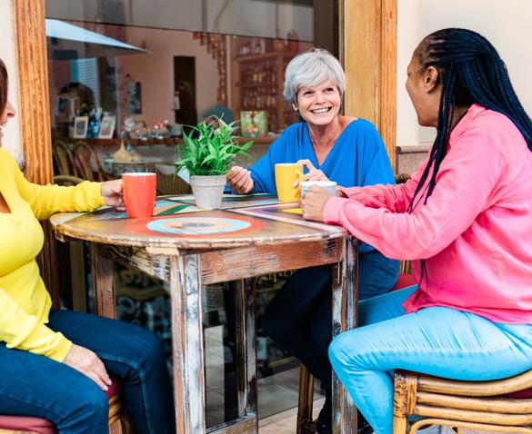 group of older women sitting and laughing at a table